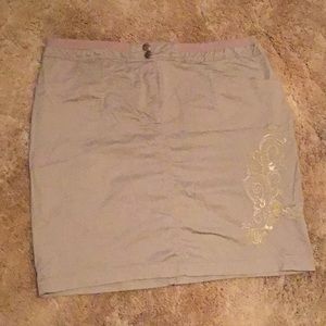 Tan skirt with gold stitching.